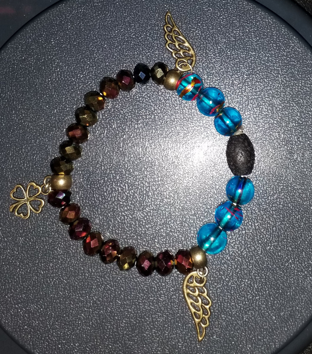 Turquoise and golden bronze deflection bracelet with wing and 4 leaf clover charms